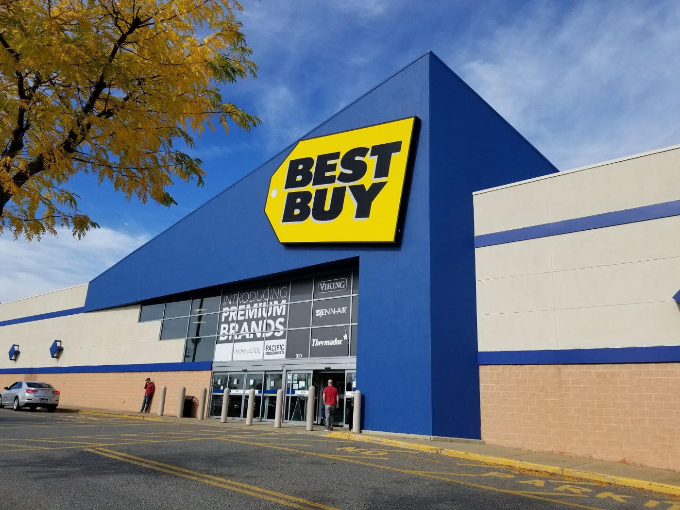 Best Buy storefront with blue exterior, yellow logo sign, and entrance doors